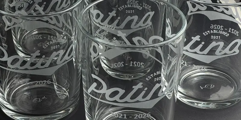 Bodega glasses engraved with a business’s script logo and anniversary dates