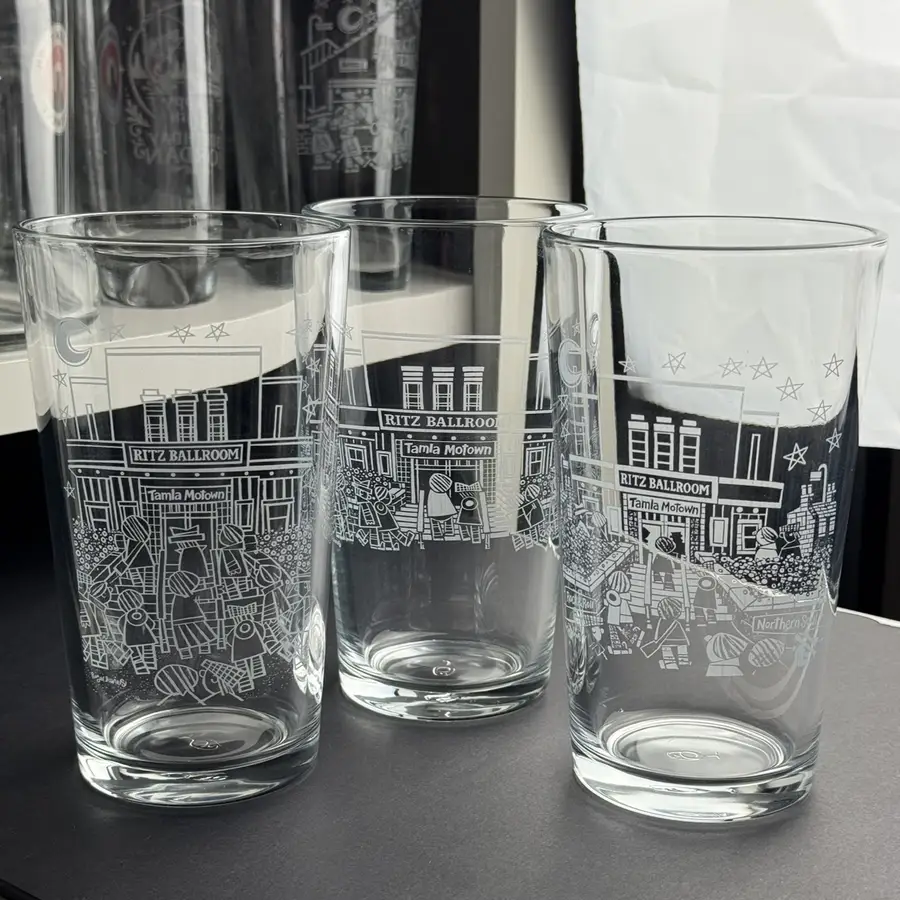 Three pints engraved with an artist’s detailed line illustration of a ballroom scene