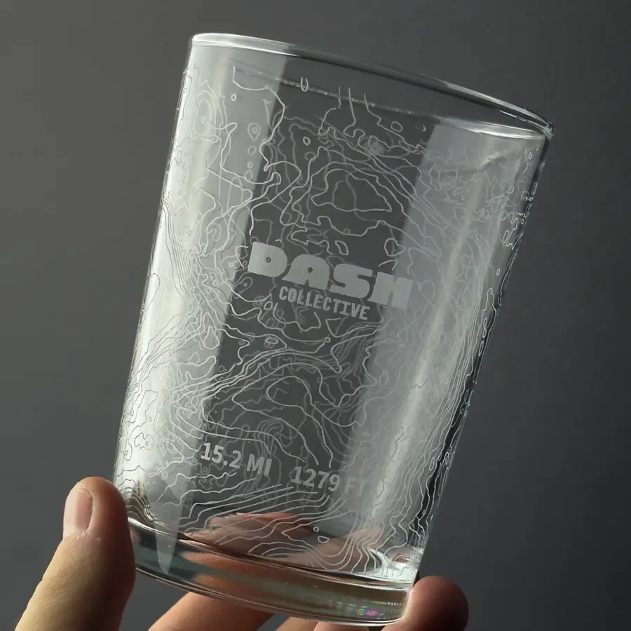 A glass engraved with contour lines wrapping the whole circumference, held up to the light